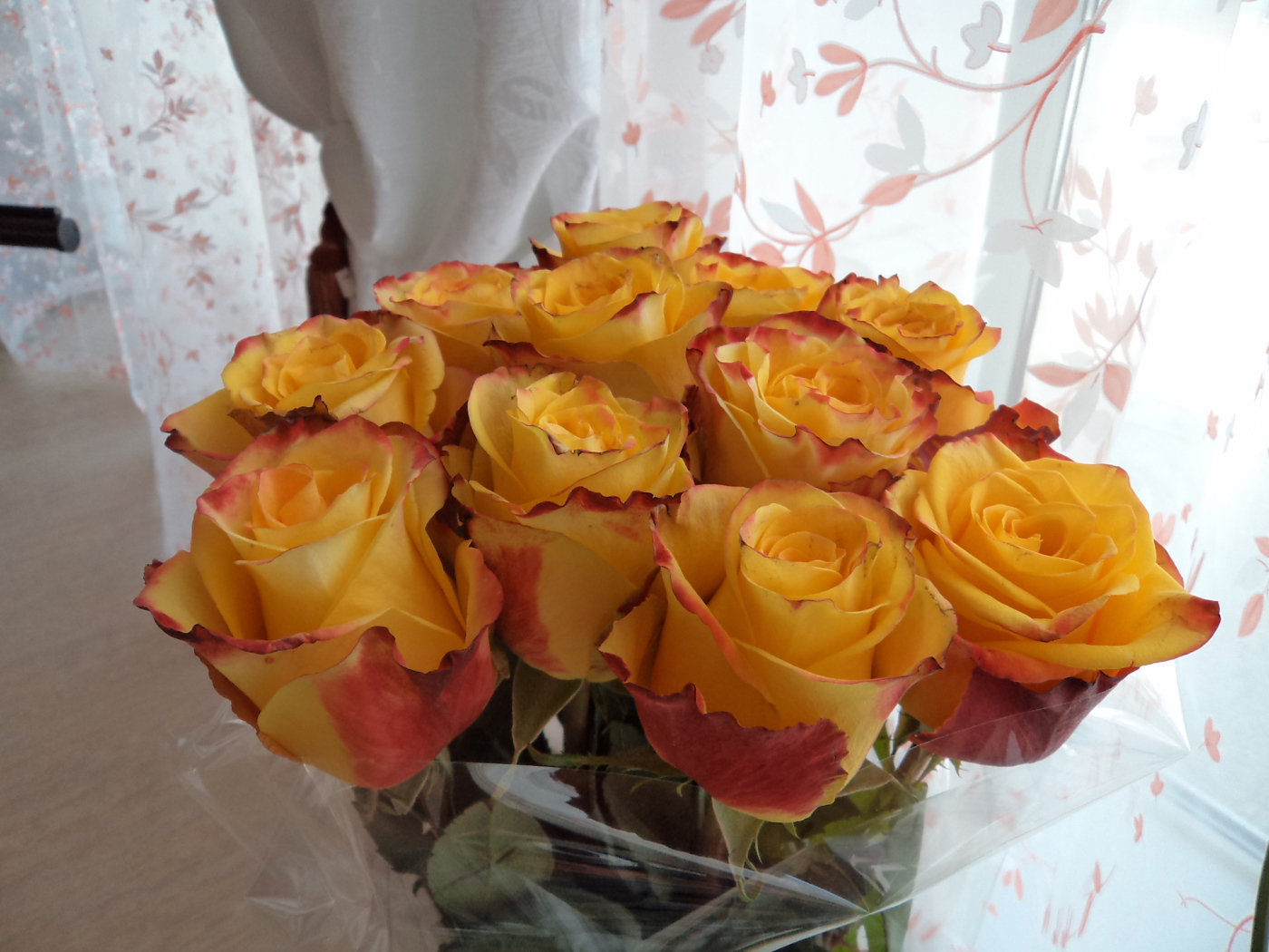 Красивый букет желтых роз в вазе у окна