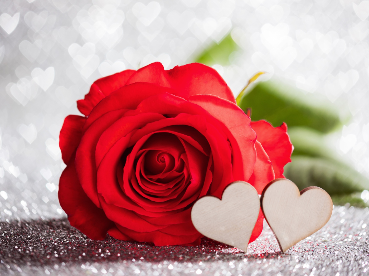 Красивая красная роза с двумя деревянными сердечками