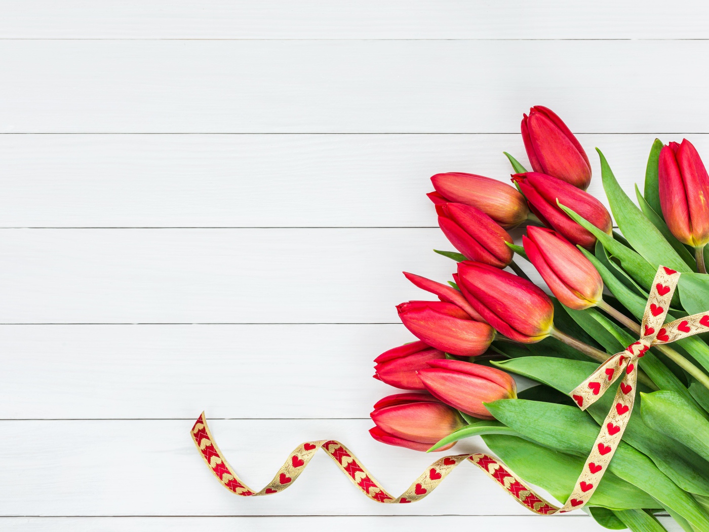 Букет красных тюльпанов с лентой на сером фоне