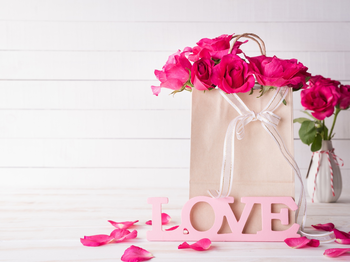 Пакет с розами на столе с надписью Love