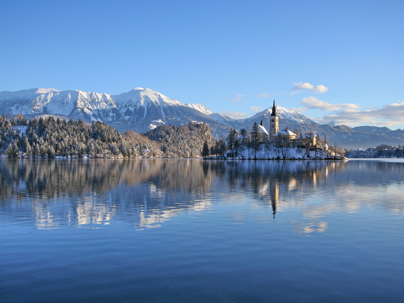 Красивый вид на заснеженные горы и замок у озера 