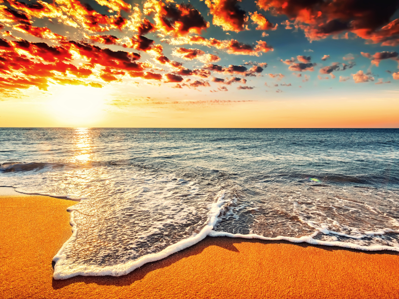 Белая морская пена на оранжевом песке под красивым небом