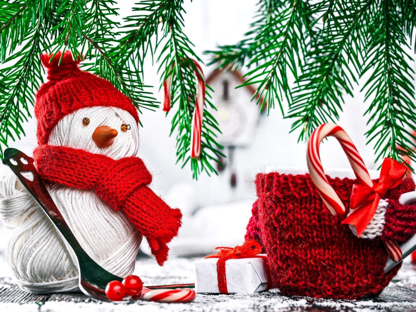 Снеговик из ниток на столе с чашкой и елочными ветками