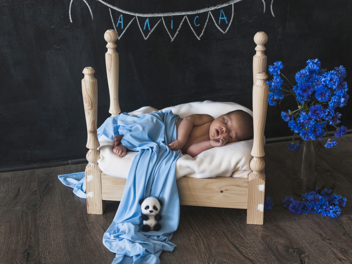 Грудной ребенок спит на деревянной кровати