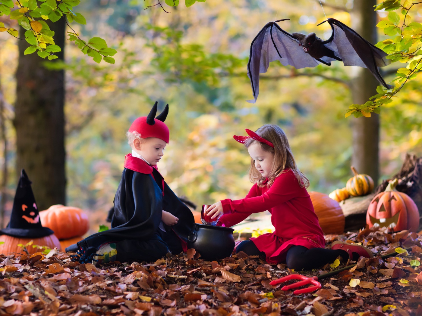 Мальчик и девочка в лесу в костюмах на праздник Хэллоуин 