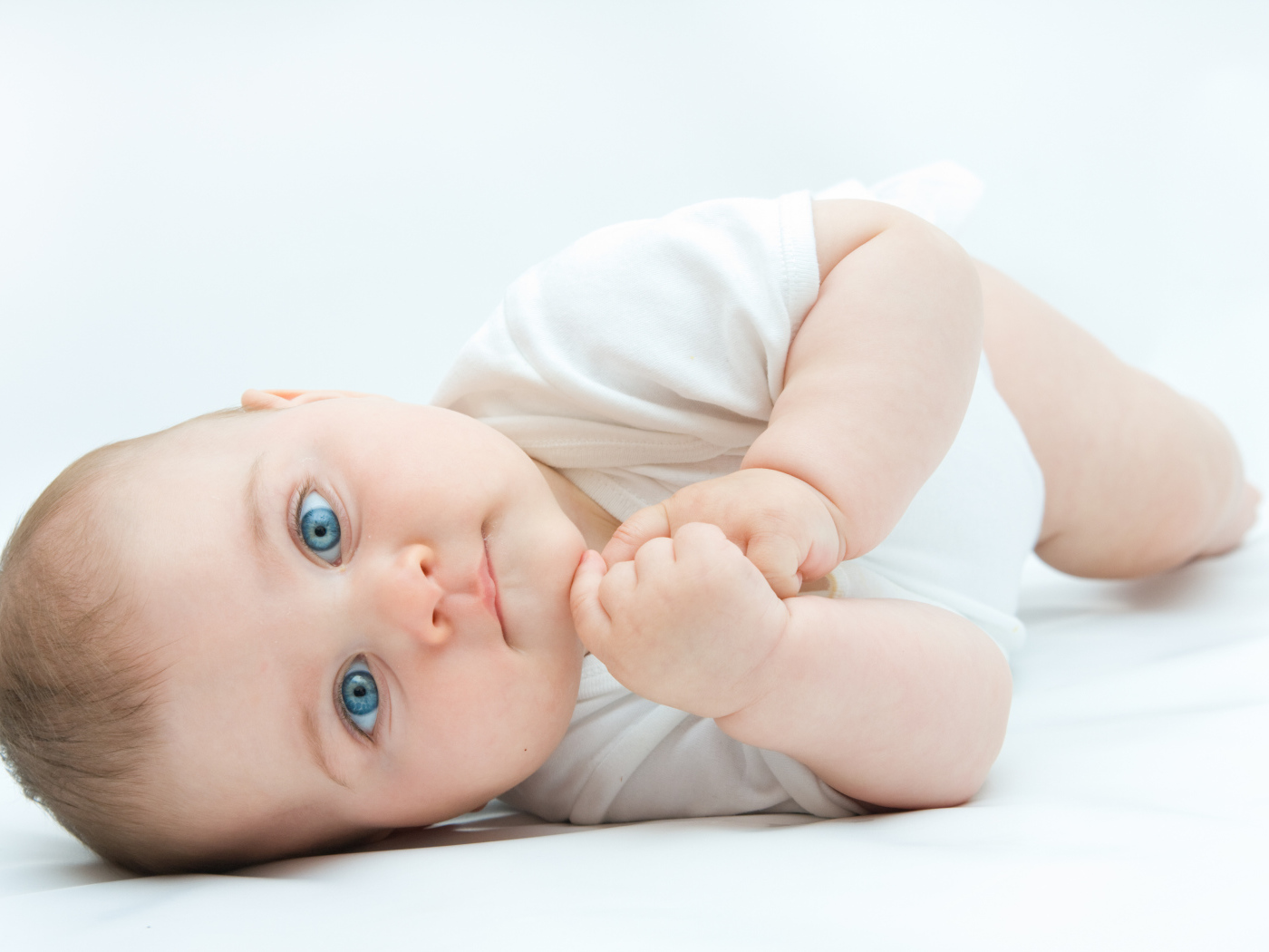 Забавный голубоглазый малыш на белом фоне