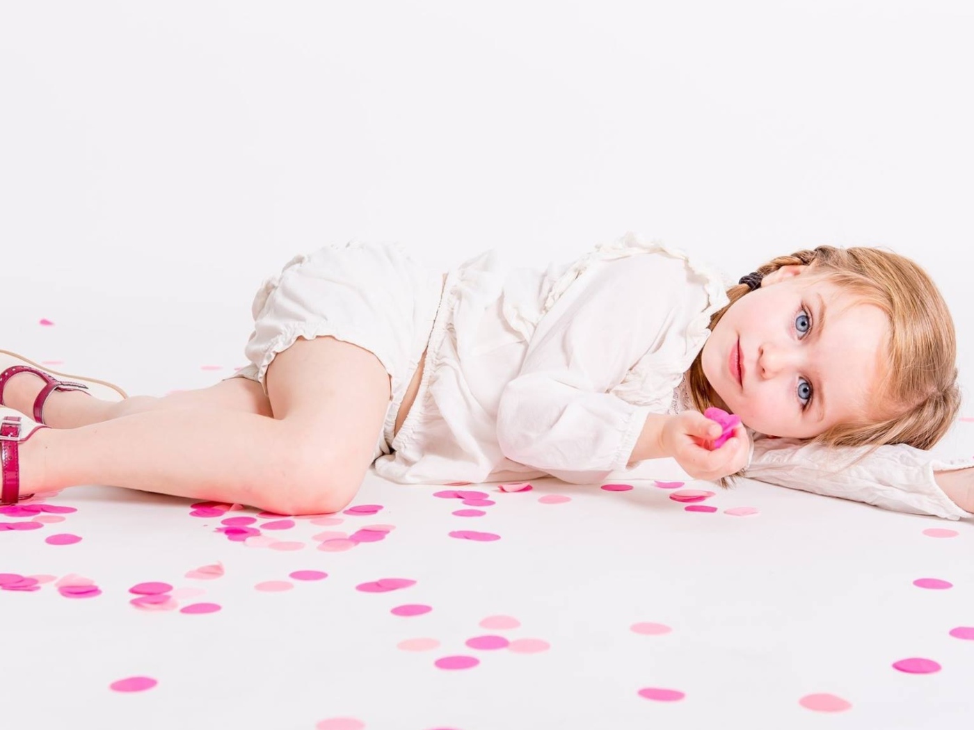 Маленькая голубоглазая девочка лежит на полу