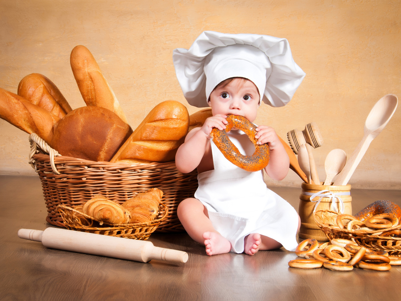Маленький мальчик с хлебобулочными изделиями на столе 
