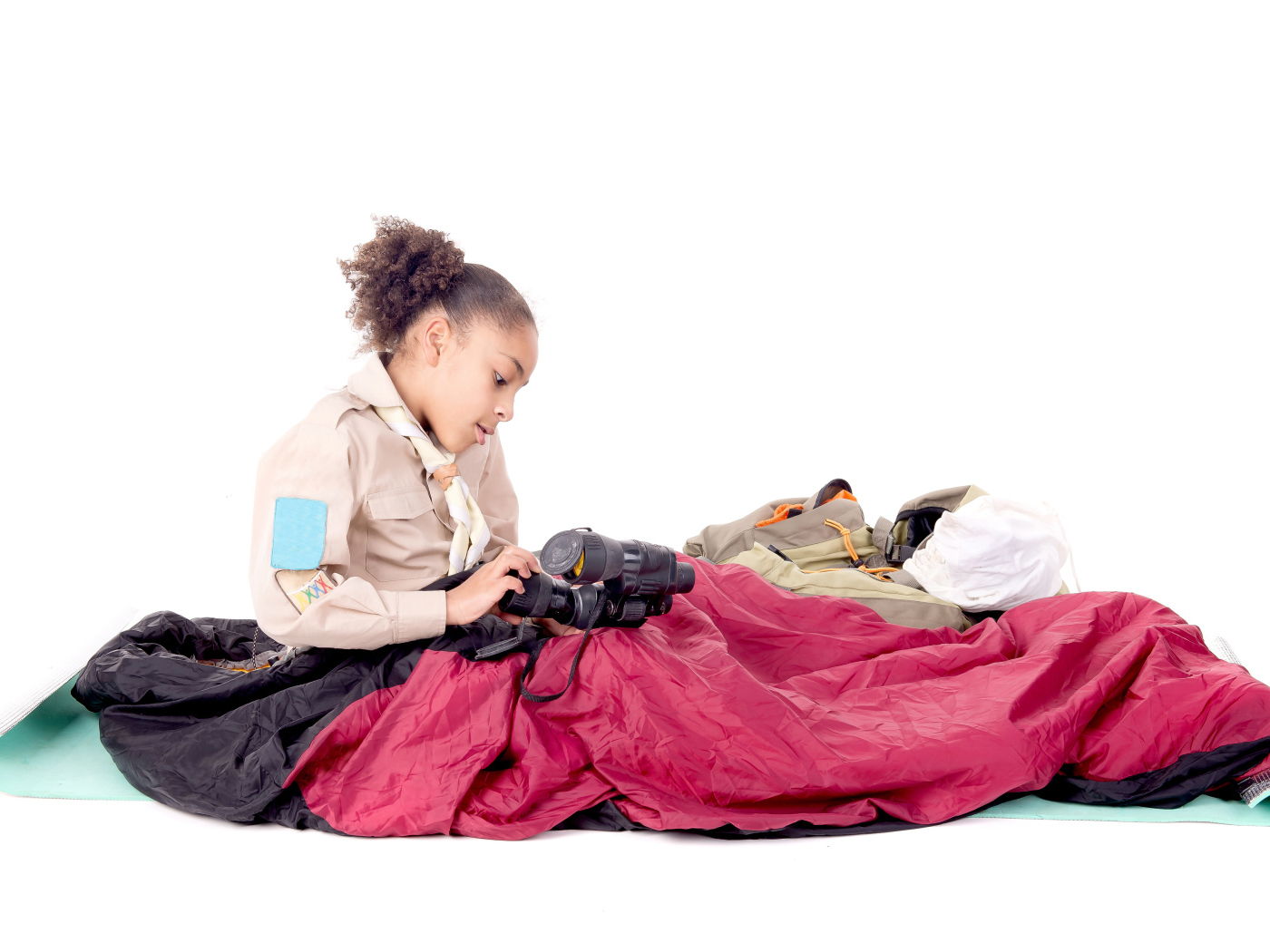 Маленькая девочка в спальном мешке с биноклем