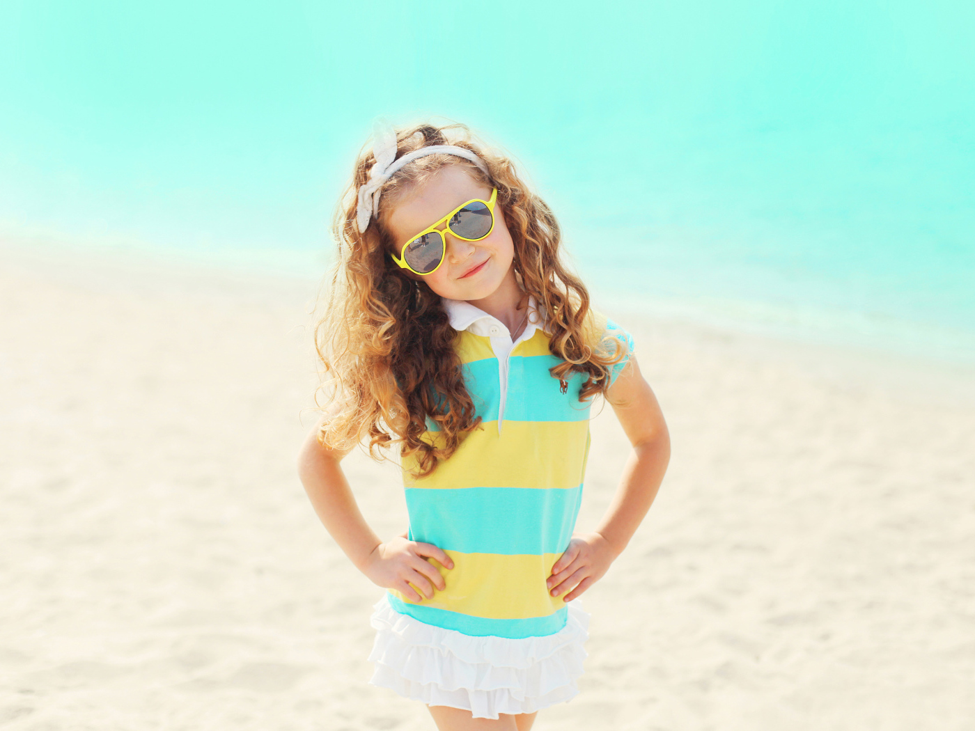 Маленькая девочка в солнечных очках на пляже