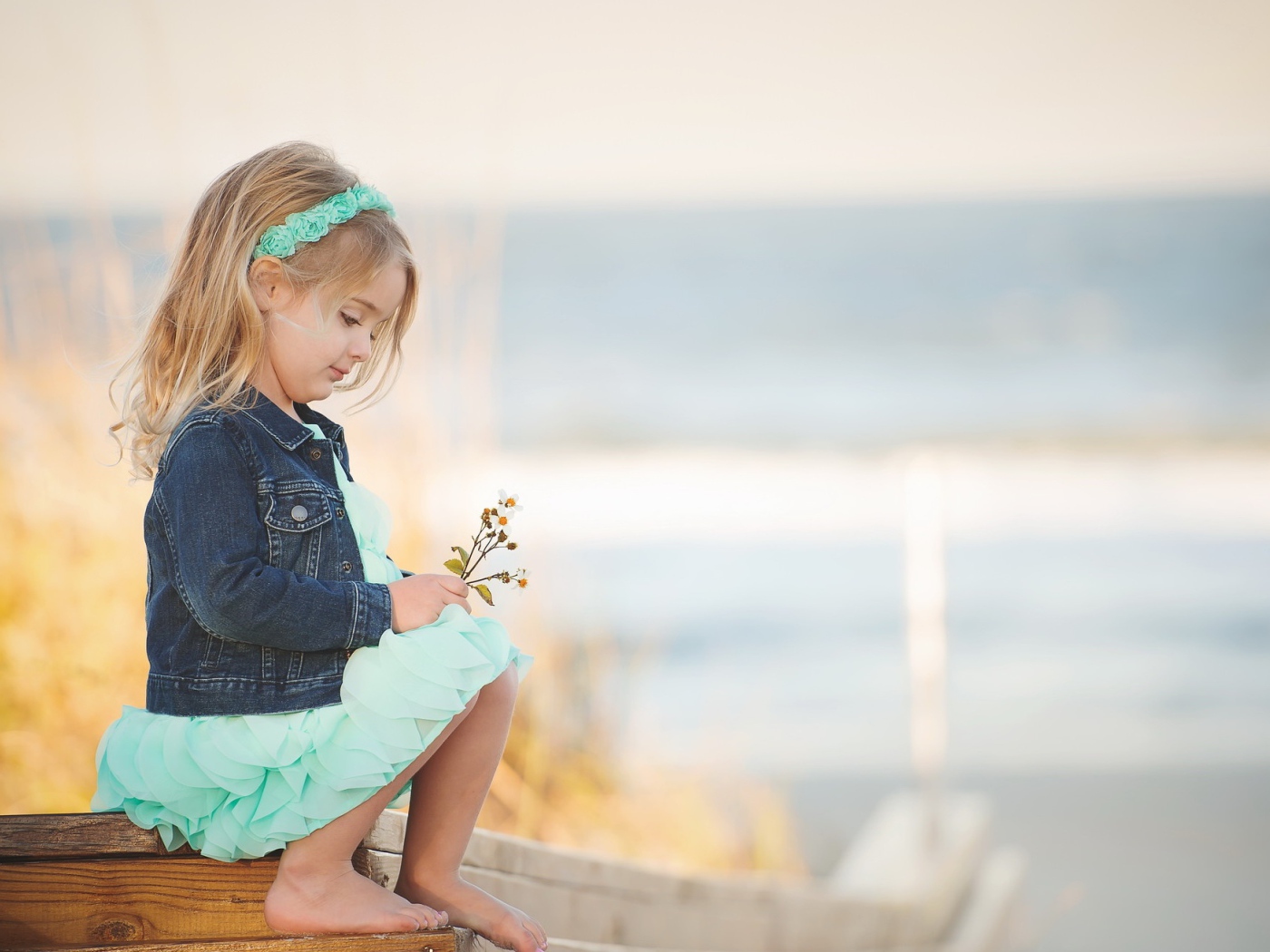 Маленькая девочка сидит на мосту