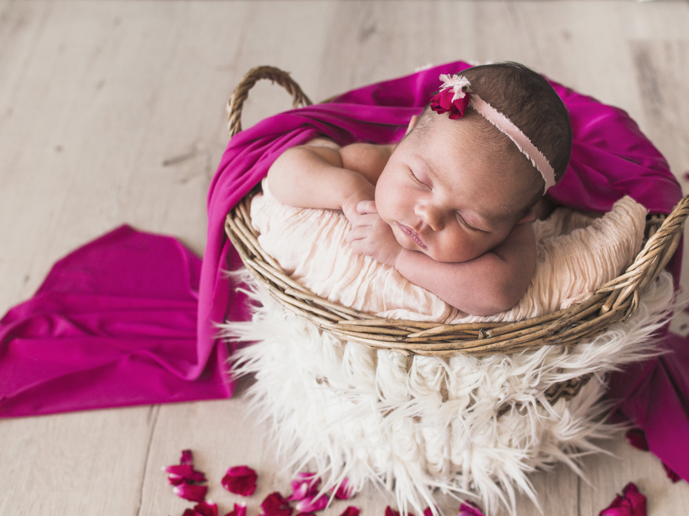 Маленькая девочка спит в корзине под покрывалом