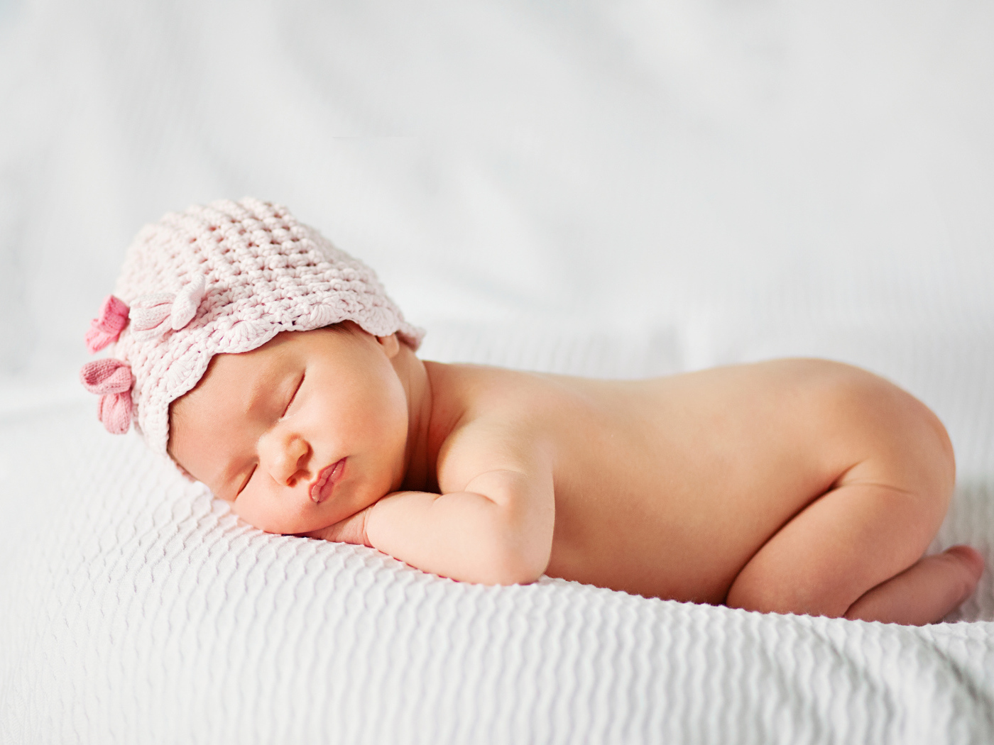 Спящий грудной ребенок девочка на белом покрывале