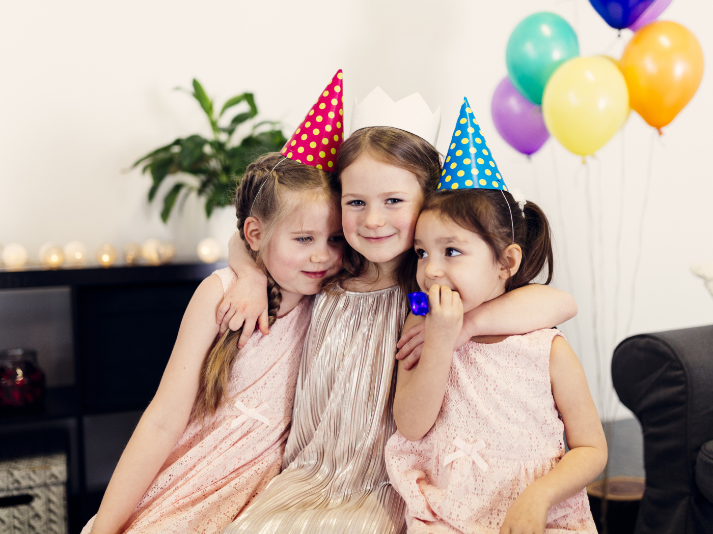 Три маленькие девочки в праздничных колпаках