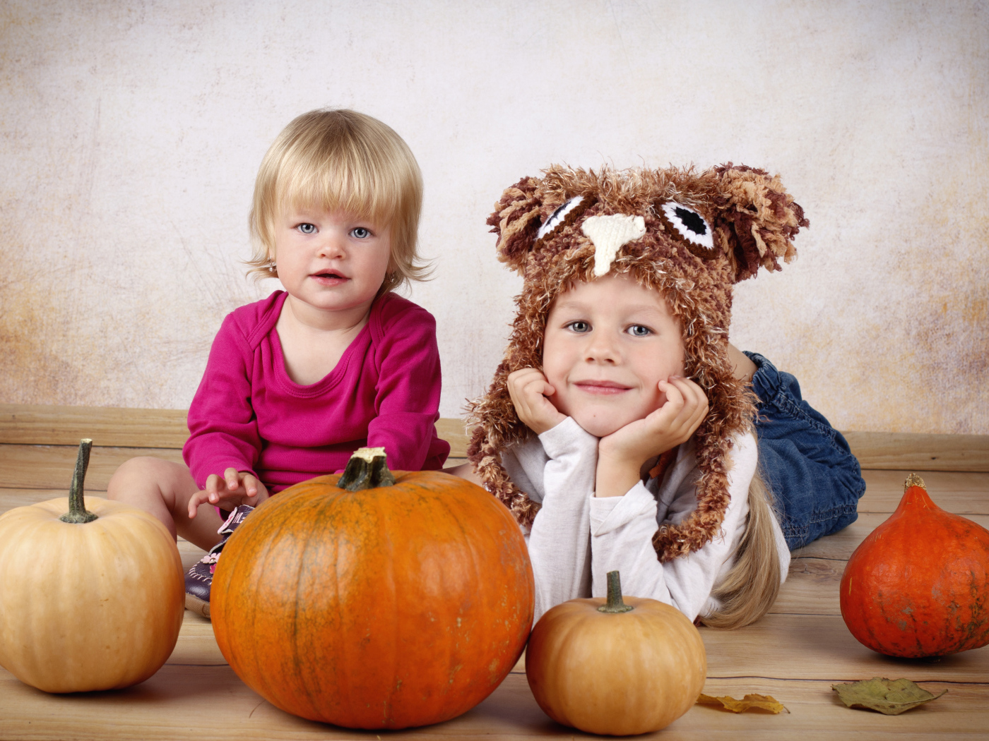 Два маленьких ребенка с тыквами в комнате
