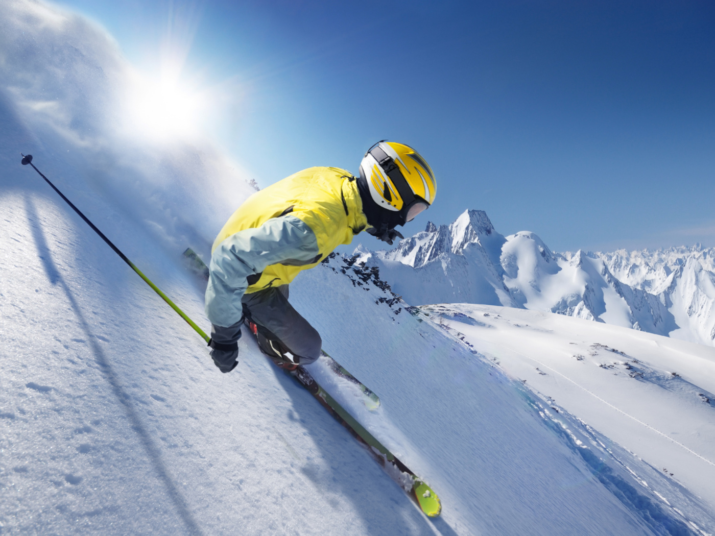 Лыжник в шлеме  спускается по заснеженному склону