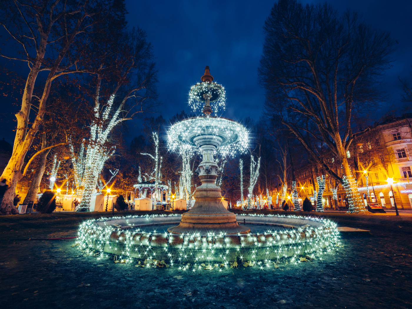 Красивый фонтан с гирляндами в городе вечером