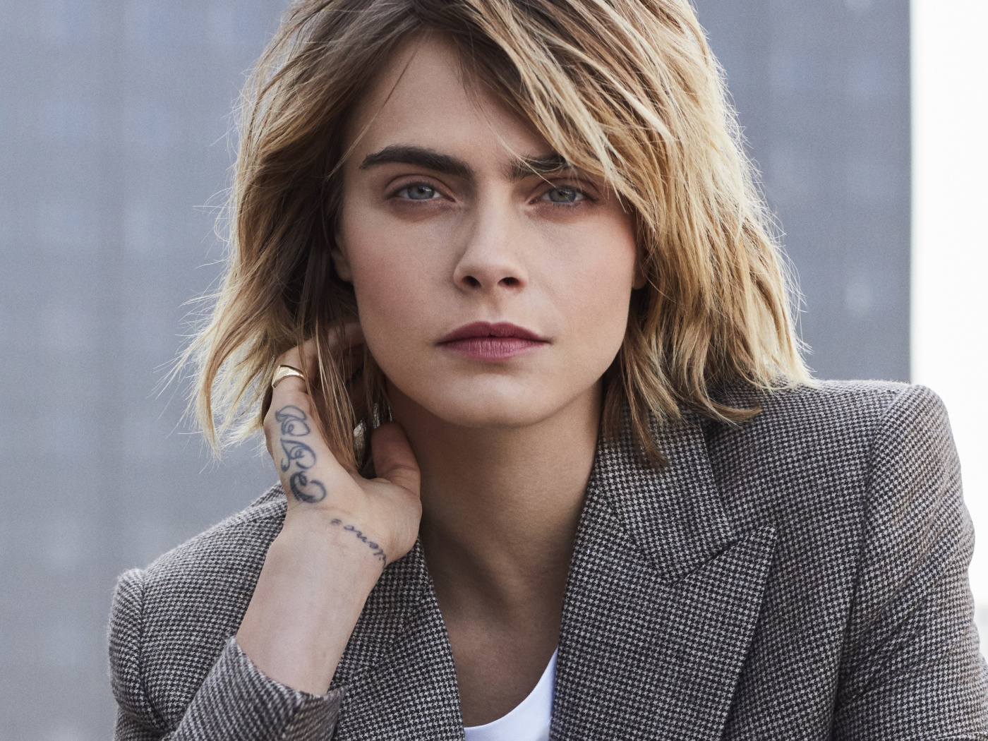 Актриса Кара Делевинь в пиджаке с татуировкой на руке