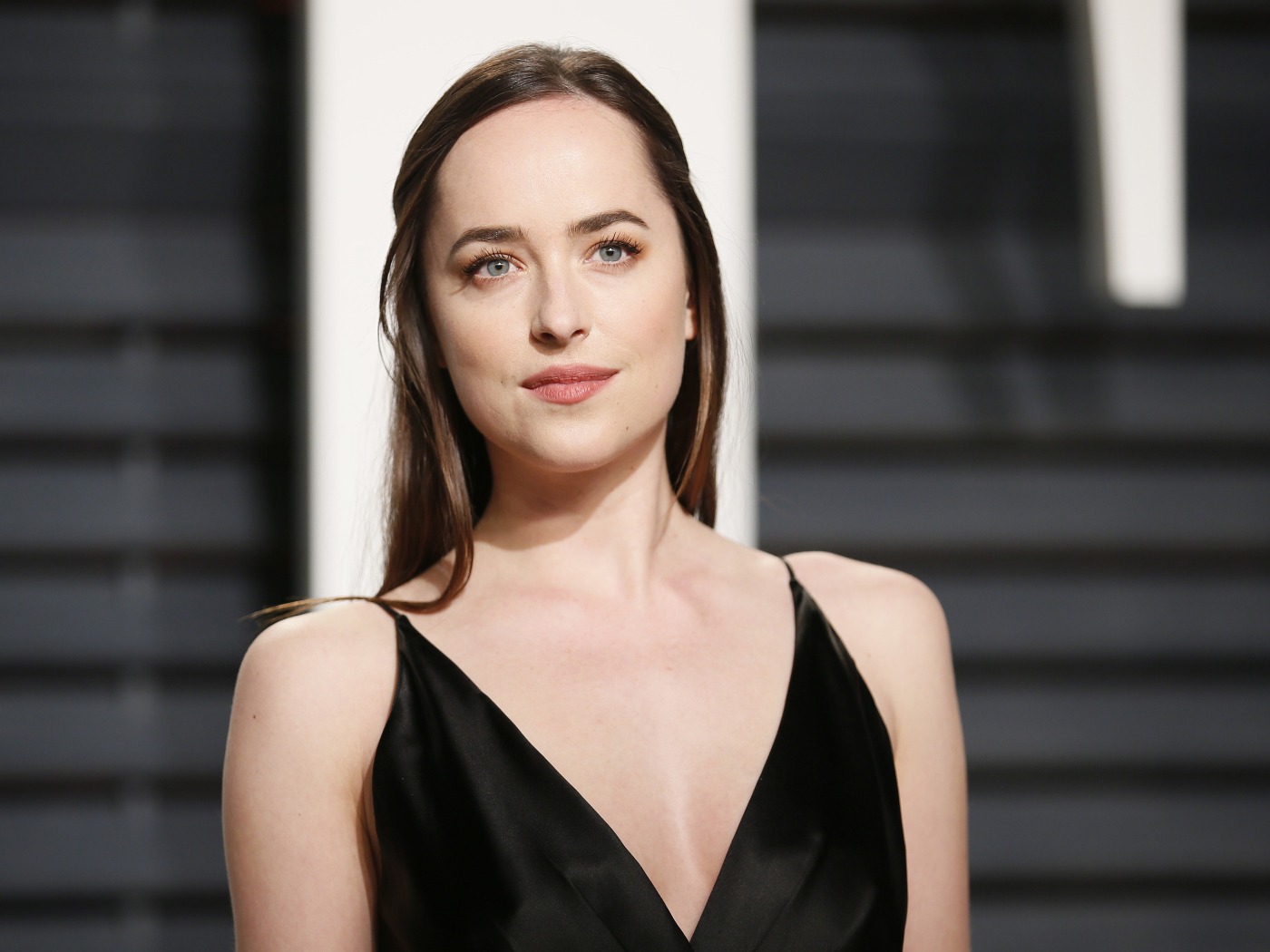 Красивая голубоглазая девушка актриса Дакота Джонсон в черном платье