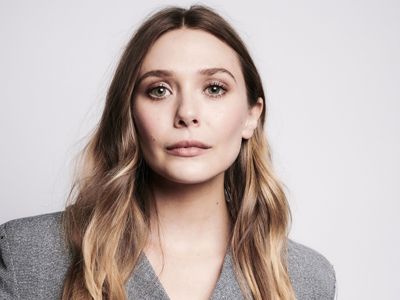 Красивая девушка,  актриса Элизабет Олсен крупным планом на сером фоне
