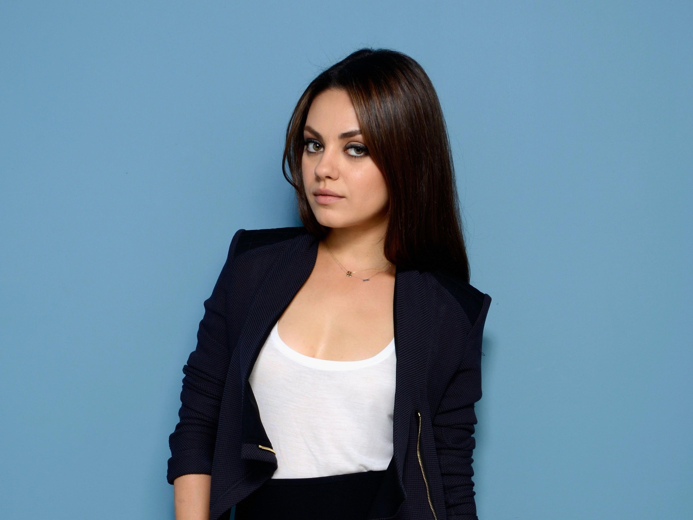 Красивая стильная актриса Мила Кунис на голубом фоне