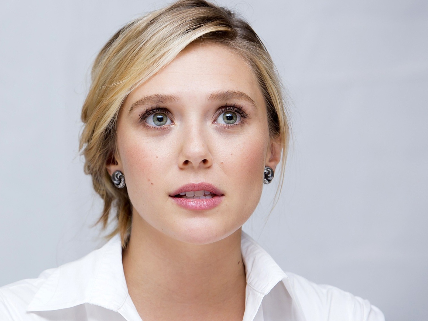 Красивая нежная блондинка, актриса Элизабет Олсен на сером фоне