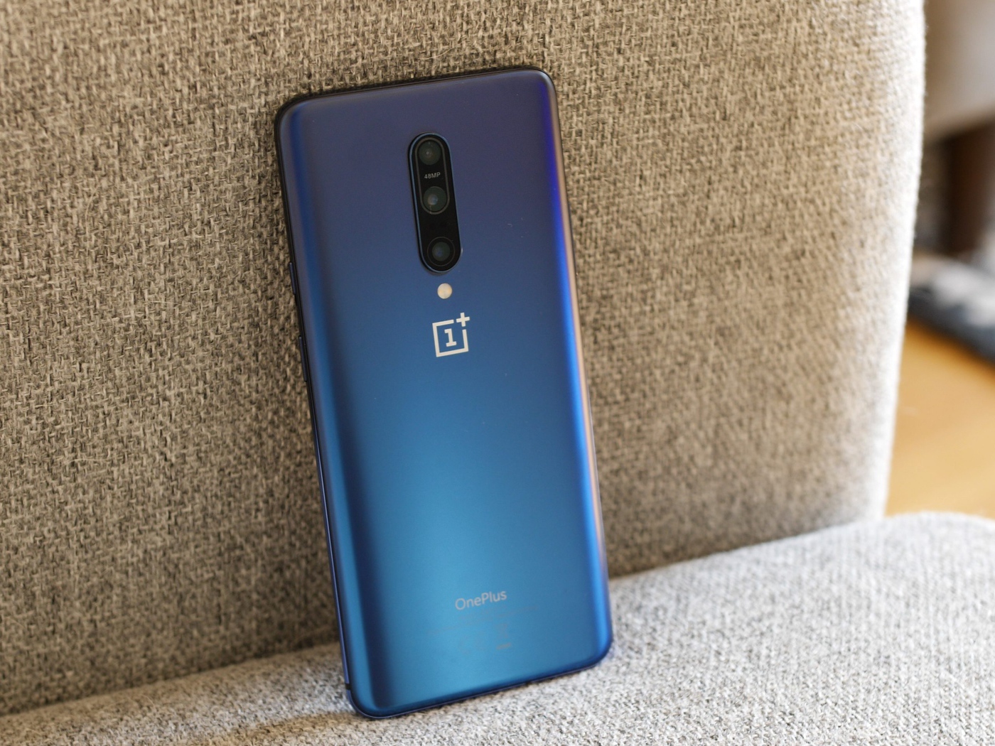 Синий смартфон ONEPLUS 7 на диване