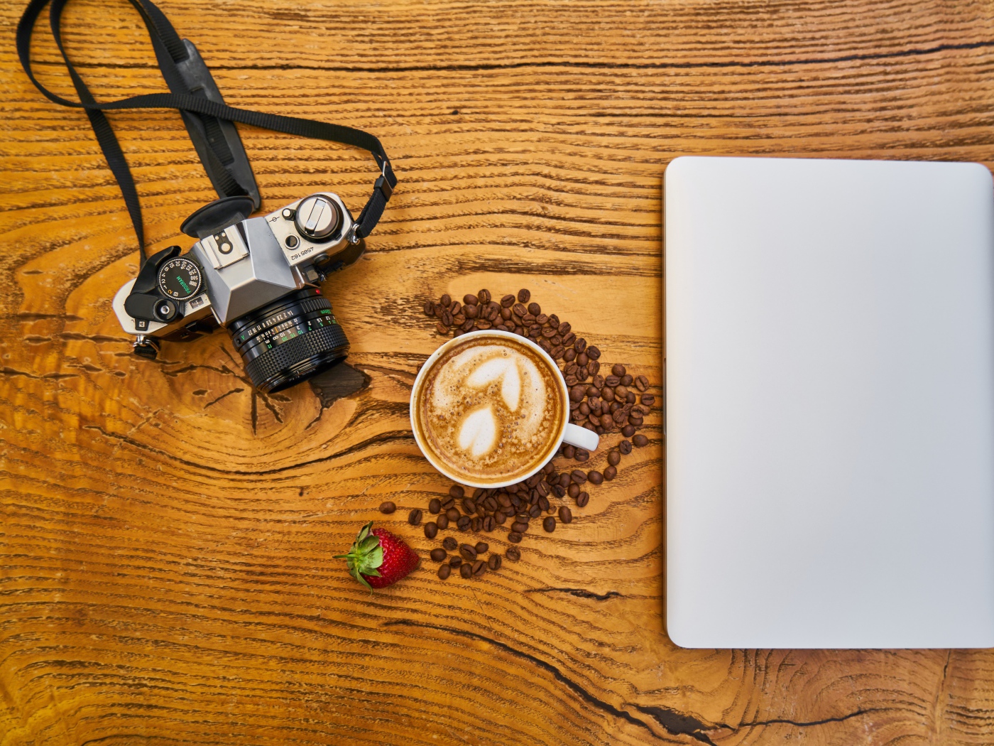 Чашка кофе на столе с фотоаппаратом и ноутбуком