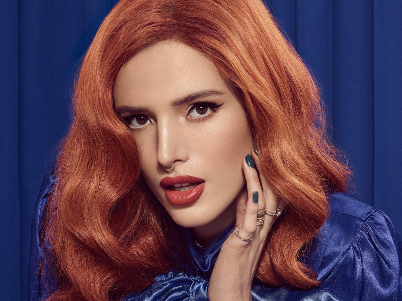Рыжеволосая актриса Белла Торн на синем фоне