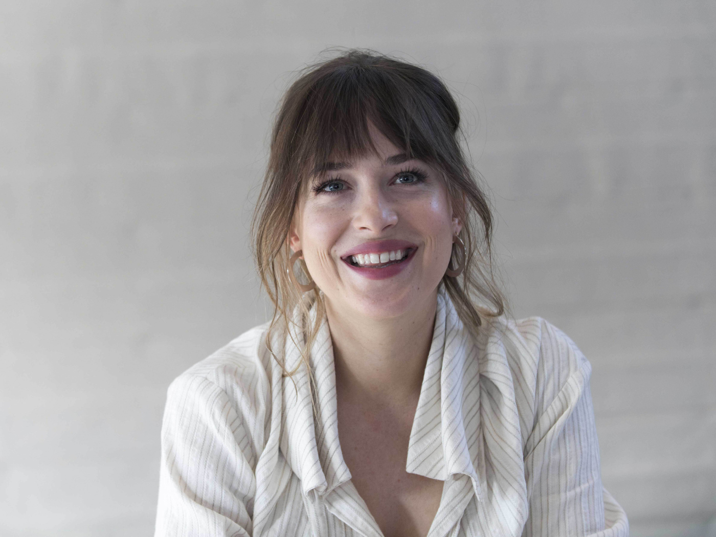 Улыбающаяся девушка актриса Дакота Джонсон в рубашке