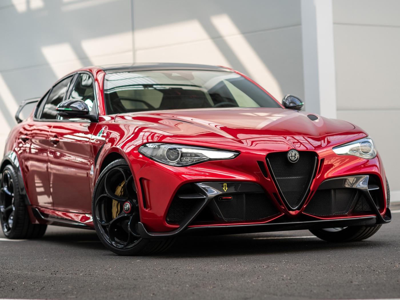 Красный автомобиль Alfa Romeo Giulia GTAm 2020 года у гаража