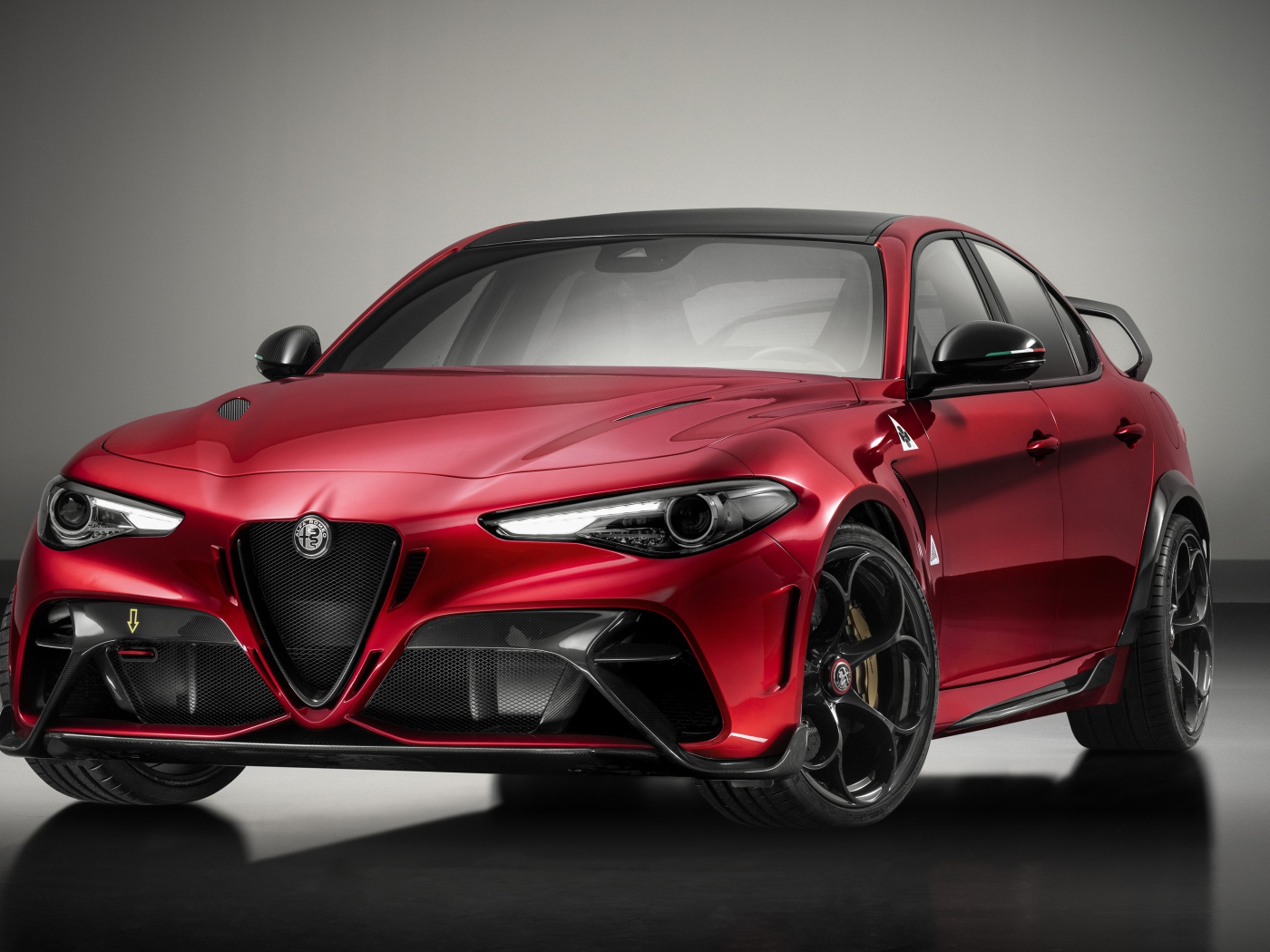 Красный автомобиль Alfa Romeo Giulia GTAm 2020 года на сером фоне