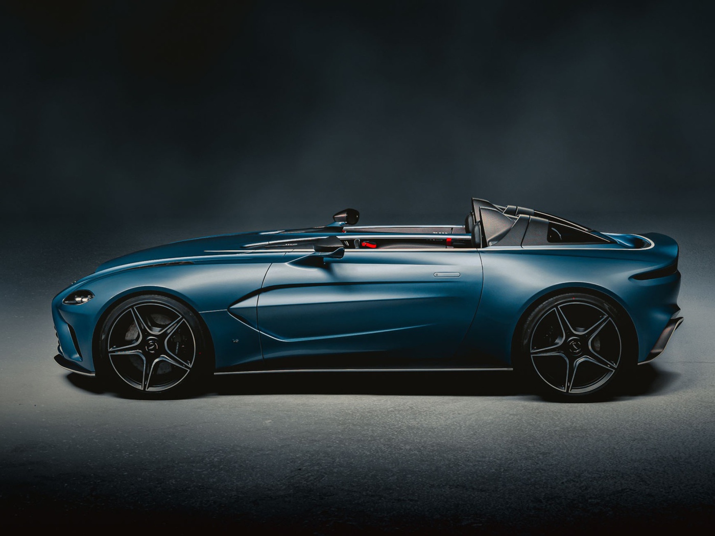 Автомобиль Aston Martin V12 Speedster 2020 года вид сбоку на сером фоне