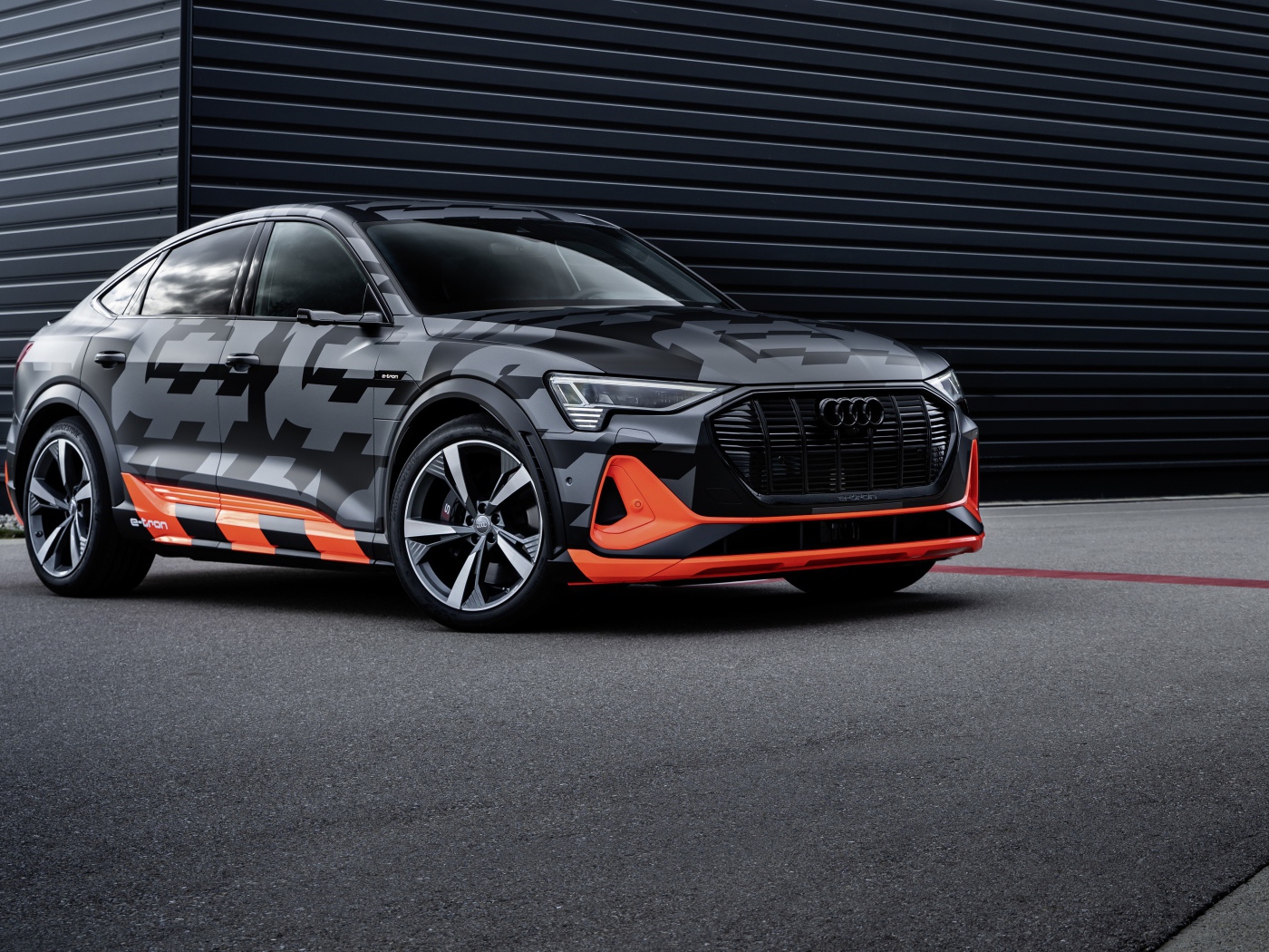 Автомобиль Audi E-Tron S Sportback Prototype 2020 года на фоне черной стены 
