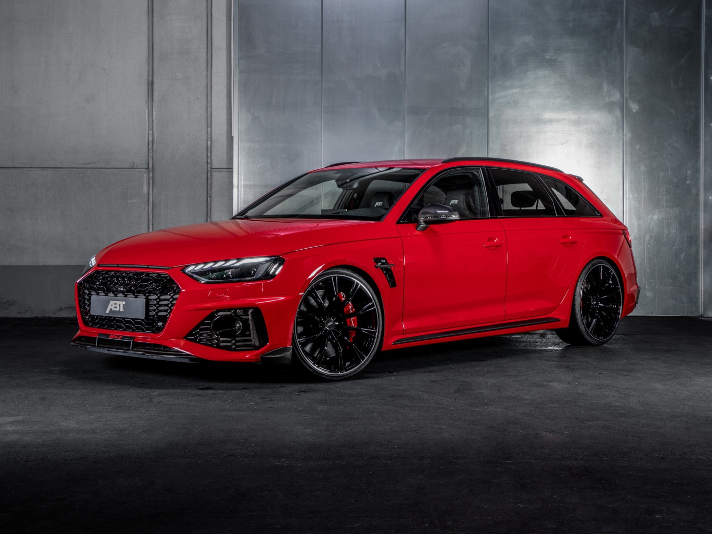 Red 2020 ABT Audi RS4 S car against a gray wall