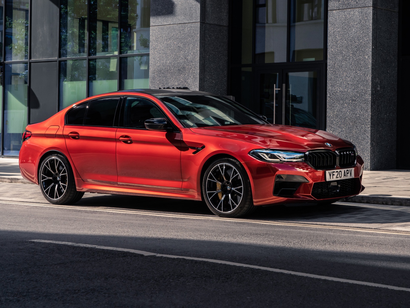Красный автомобиль BMW M5 Competition 2020 года у дома