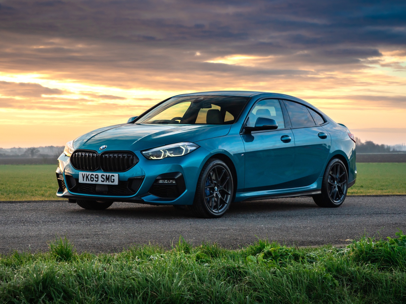 Синий автомобиль BMW 218i Gran Coupe M Sport 2020 года на фоне заката