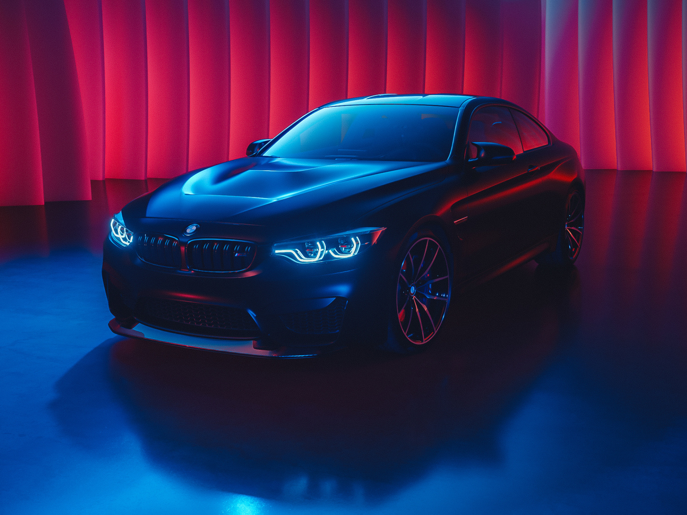 Черный автомобиль BMW M4 с включенными фарами