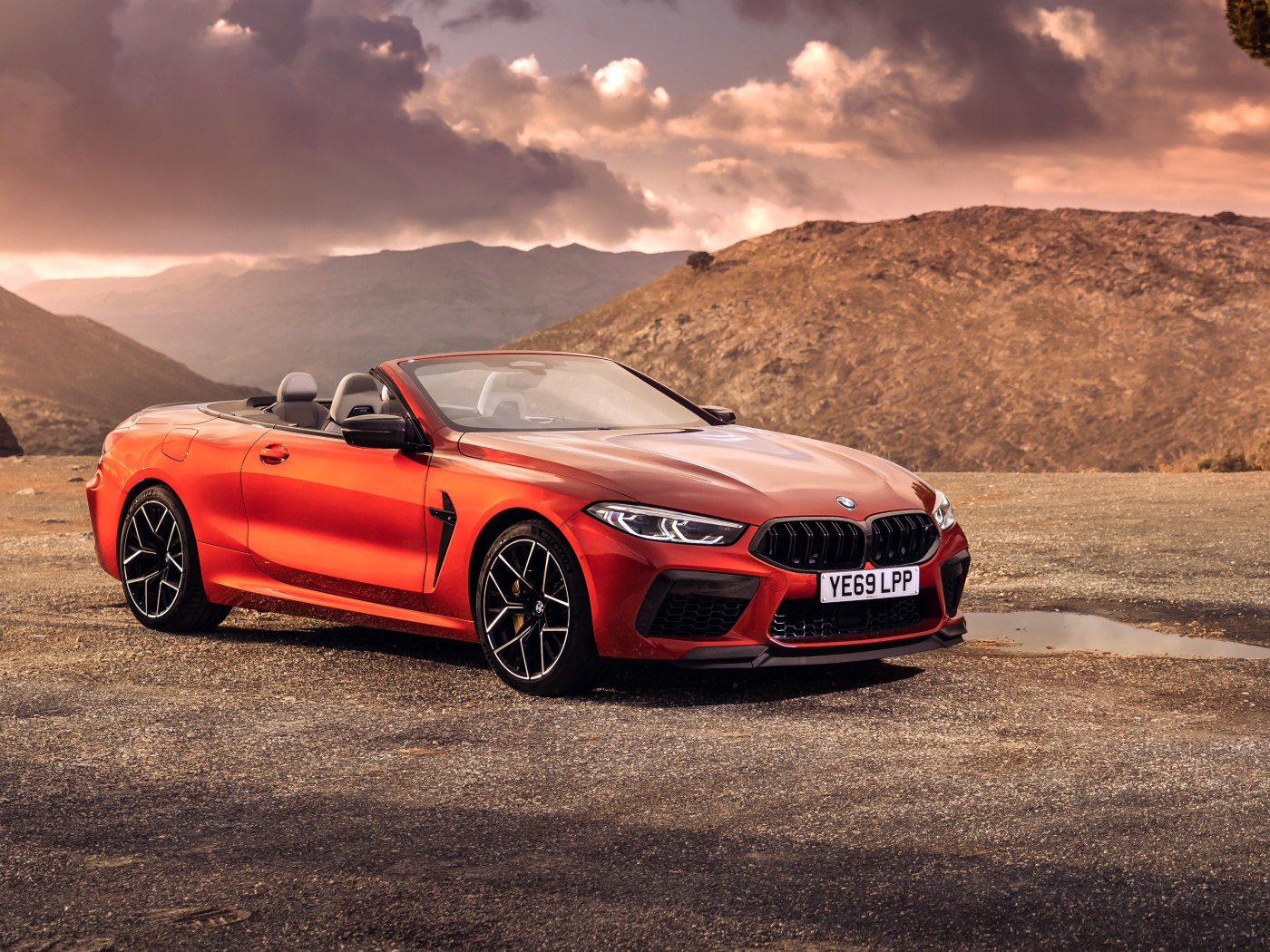 Красный кабриолет BMW M8, 2019 года у гор