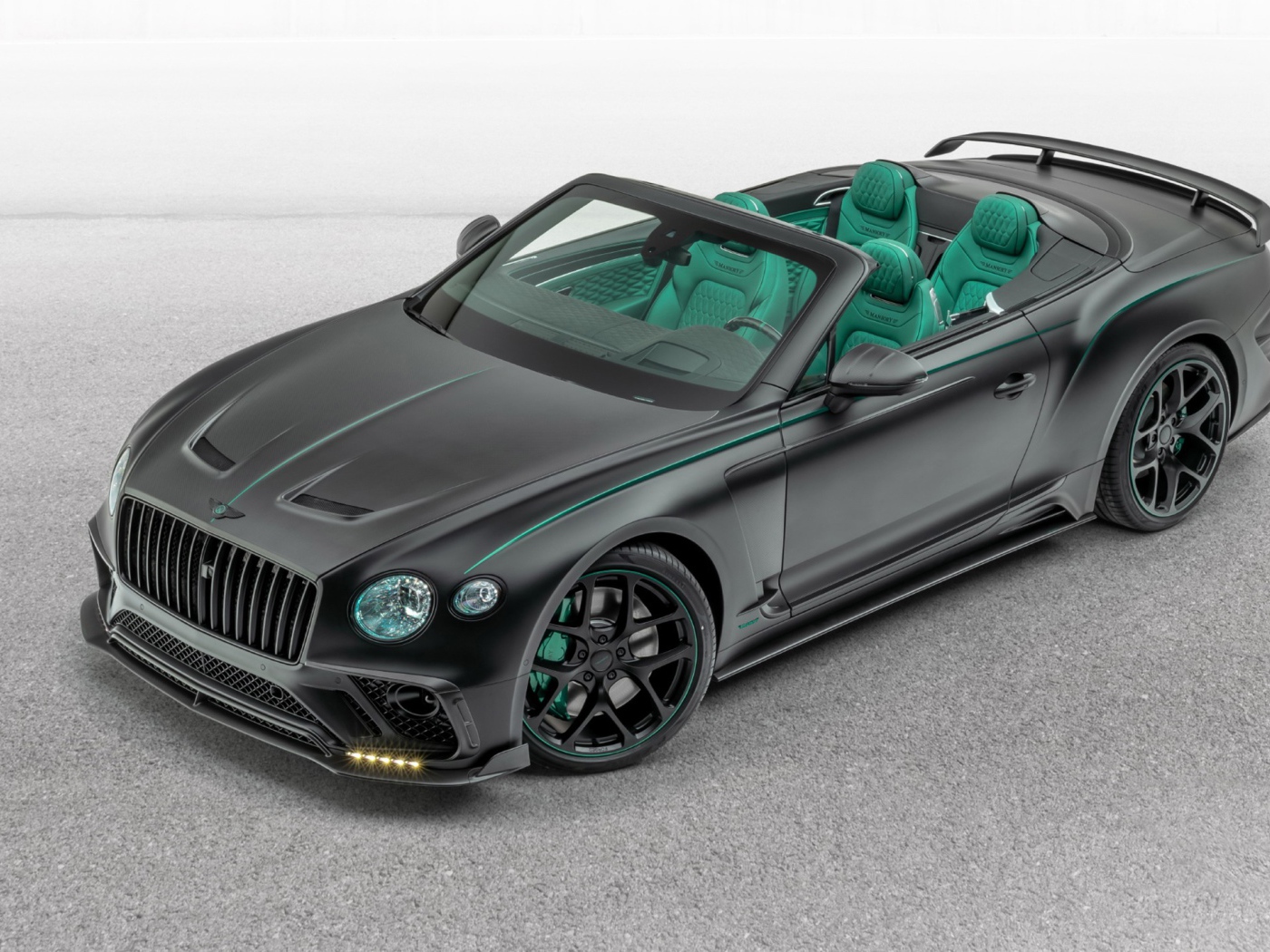 Черный автомобиль Mansory Bentley Continental GT V8 Convertible 2020 года на сером фоне