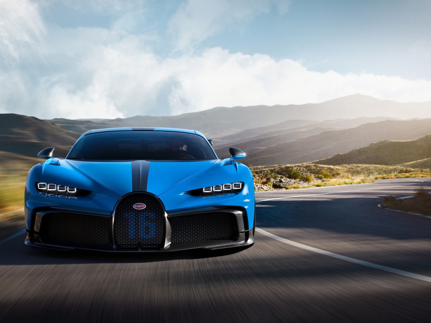 Синий автомобиль Bugatti Chiron Pur Sport 2020 года на трассе в горах 
