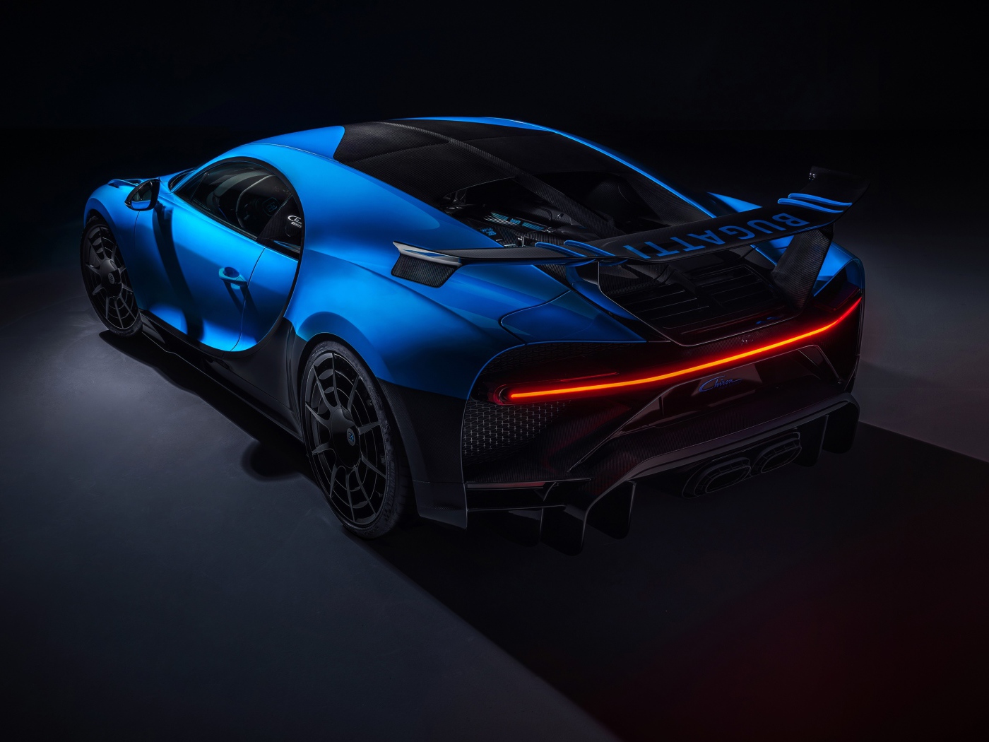Синий автомобиль Bugatti Chiron Pur Sport 2020 года вид сзади на черном фоне