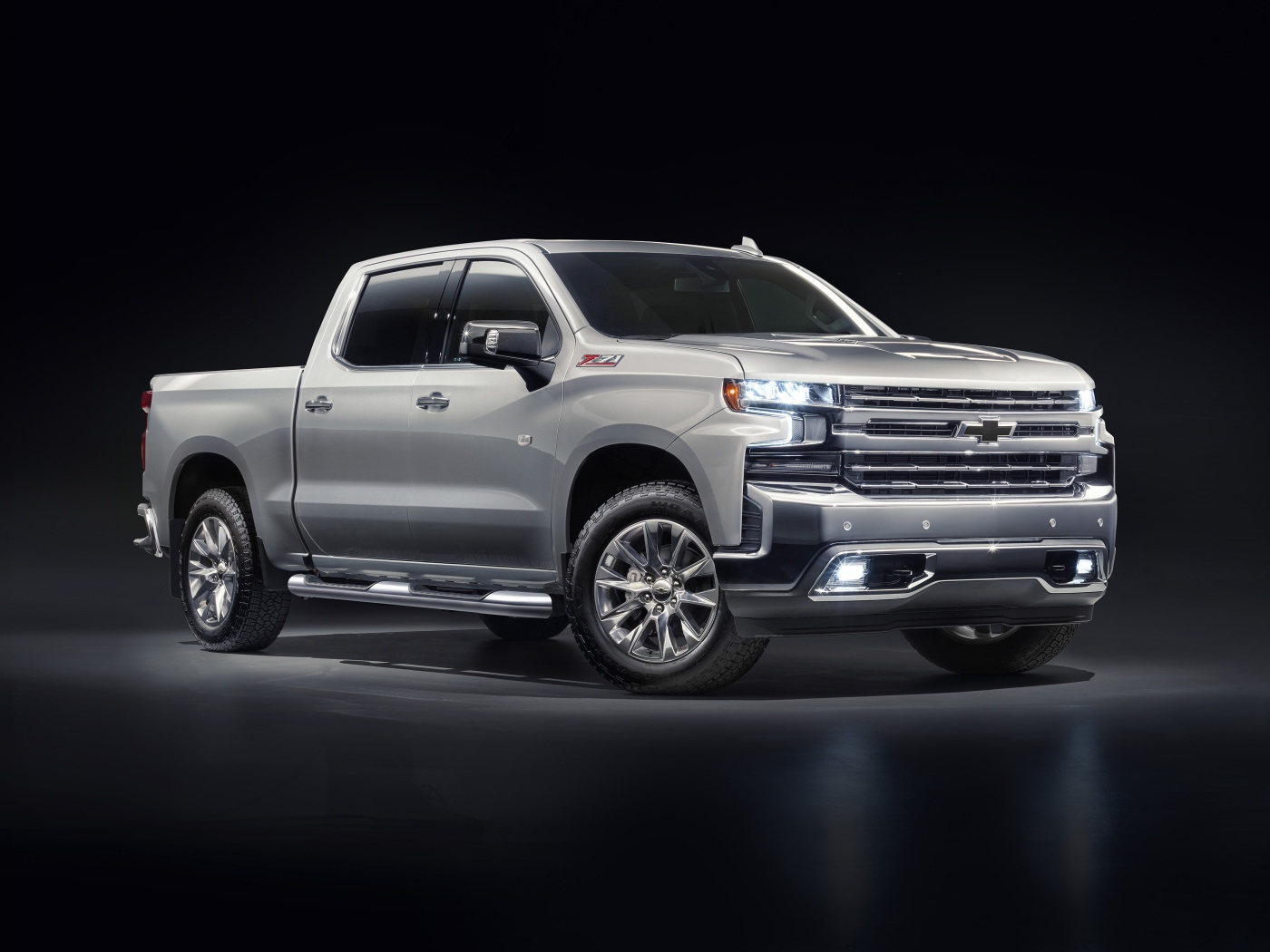 Серебристый автомобиль Chevrolet Silverado 1500 LTZ Z71 Premium Edition 2020 года на черном фоне