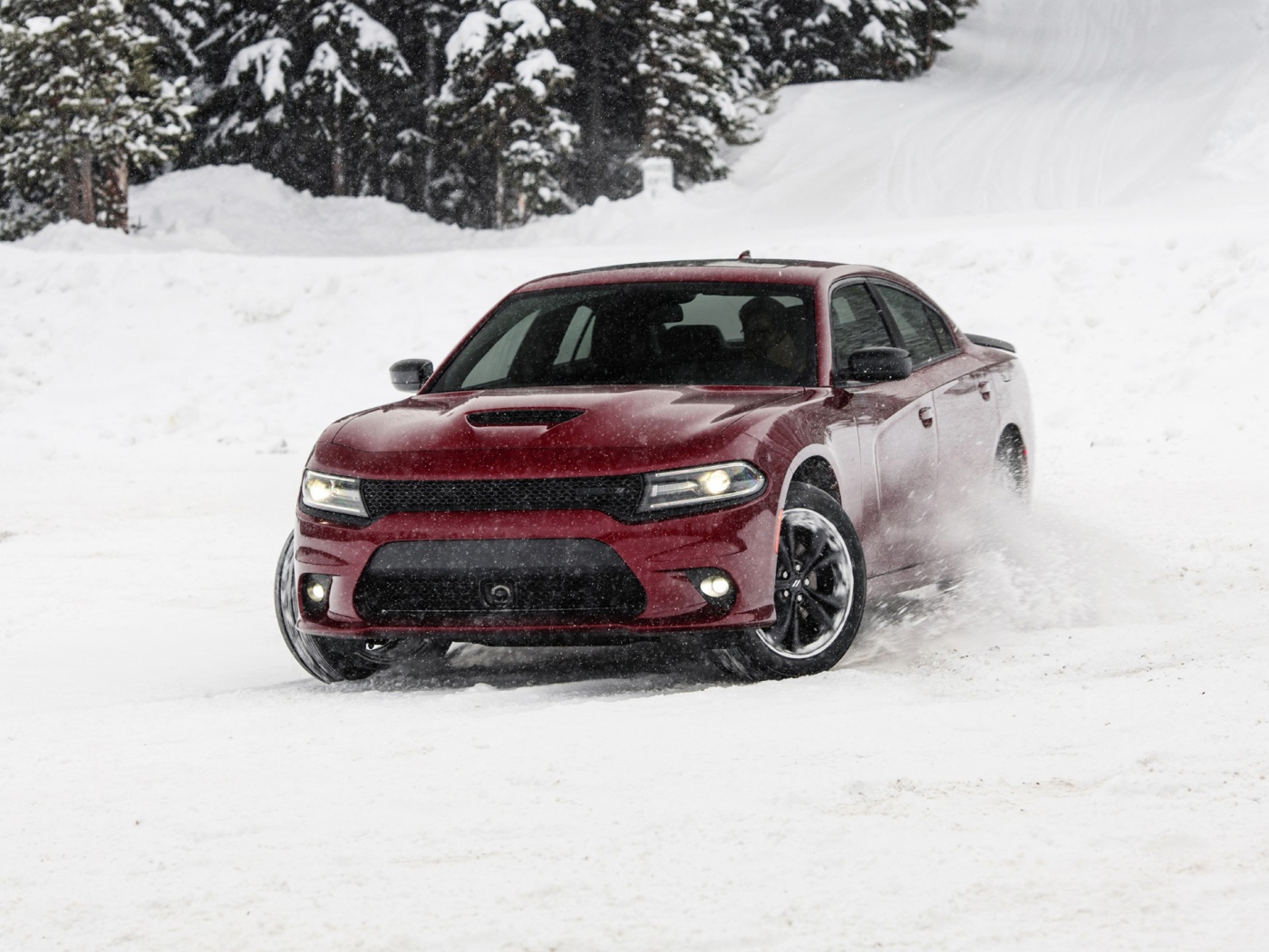 Красный автомобиль  Dodge Charger GT AWD, 2020 года едет по снегу