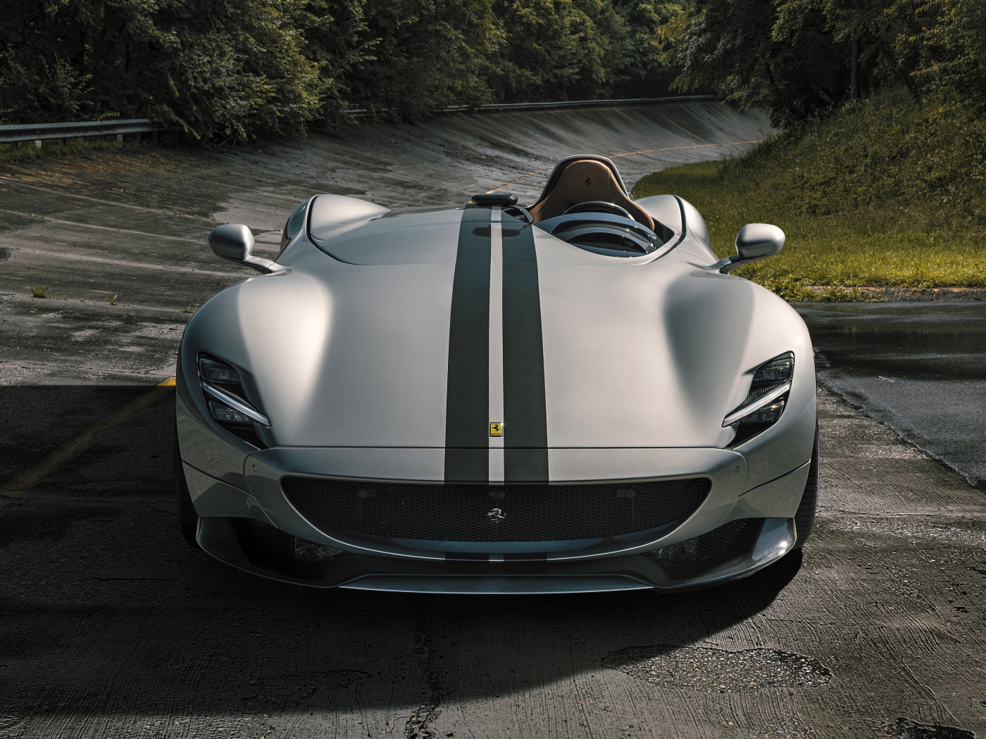 Серебристый кабриолет  Ferrari Monza SP1 2020 года на мокрой трассе 