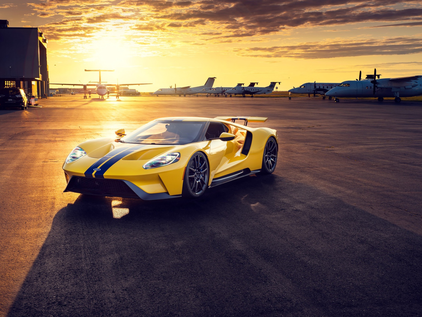 Желтый спортивный автомобиль Ford GT на закате