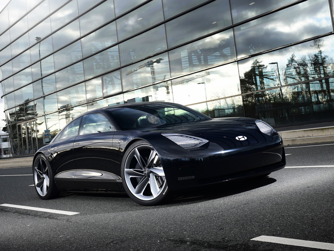 Черный автомобиль Hyundai Prophecy 2020 года у стеклянного здания 