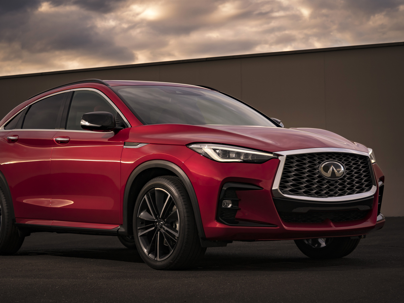 Красный автомобиль Infiniti QX55 AWD, 2022 года у стены