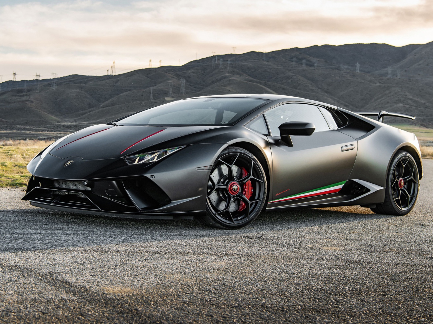 Серебристый спортивный автомобиль  Lamborghini Huracan Performante 2020 года на фоне гор 