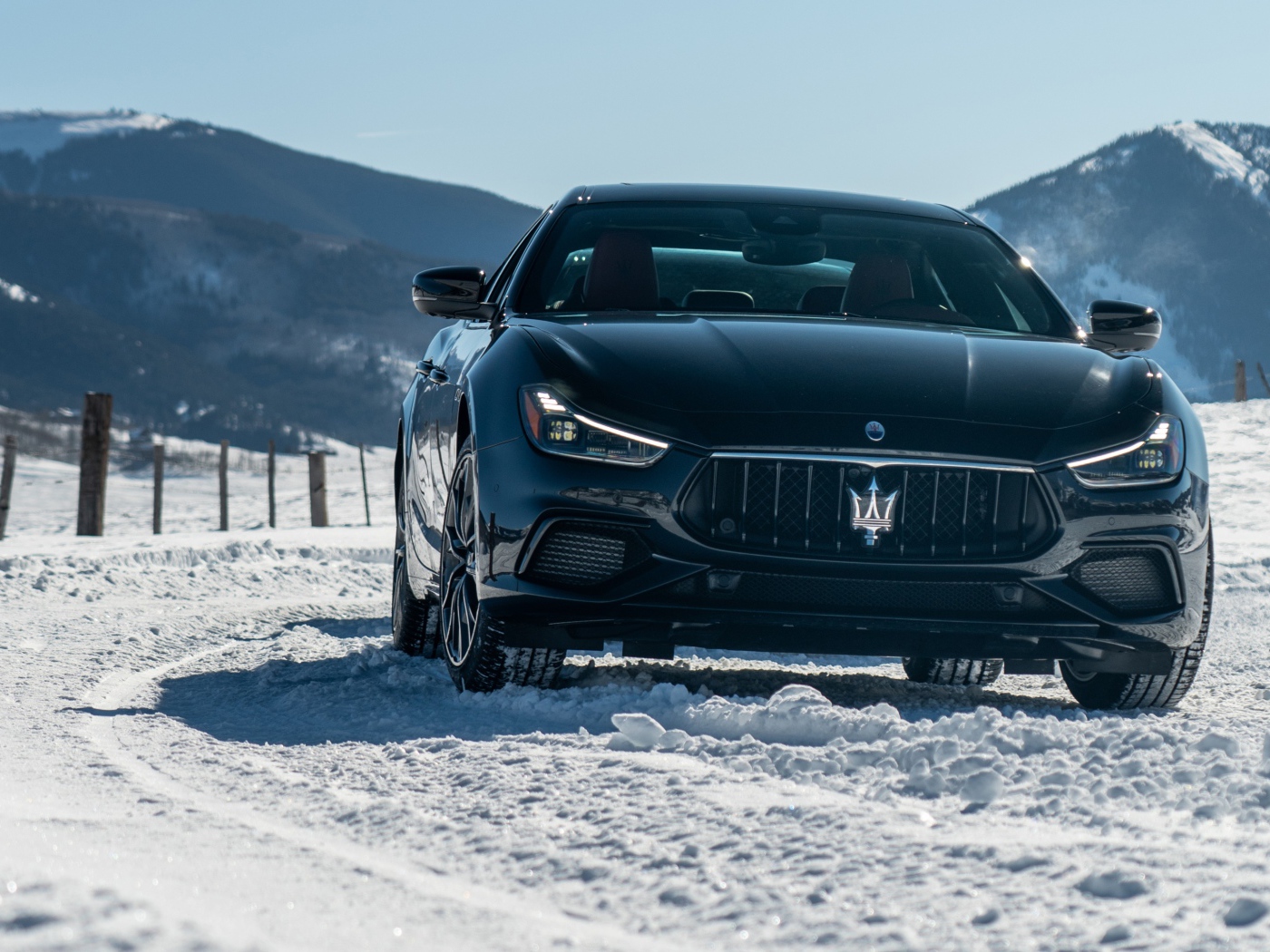 Черный автомобиль Maserati Ghibli S Q4, 2020 года едет по заснеженной дороге